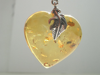 Clear butterscotch amber heart pendant. Natural clearamber heart pendant with spangles. Sterling silver mount with silver bail.